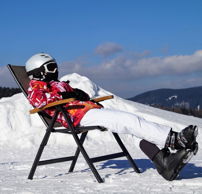 Girl skier relaxing in chair on mountain