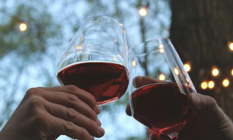 Hands toasting with red wine