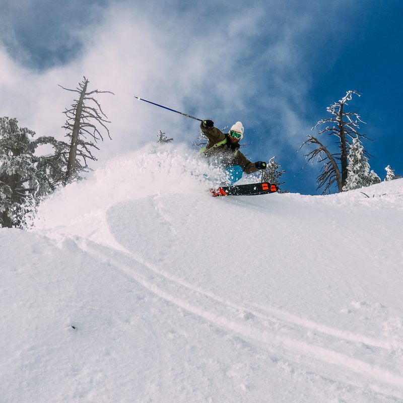 Skier spraying snow with skis