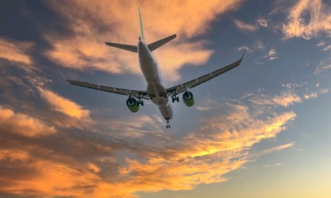 Airplane flying at sunset