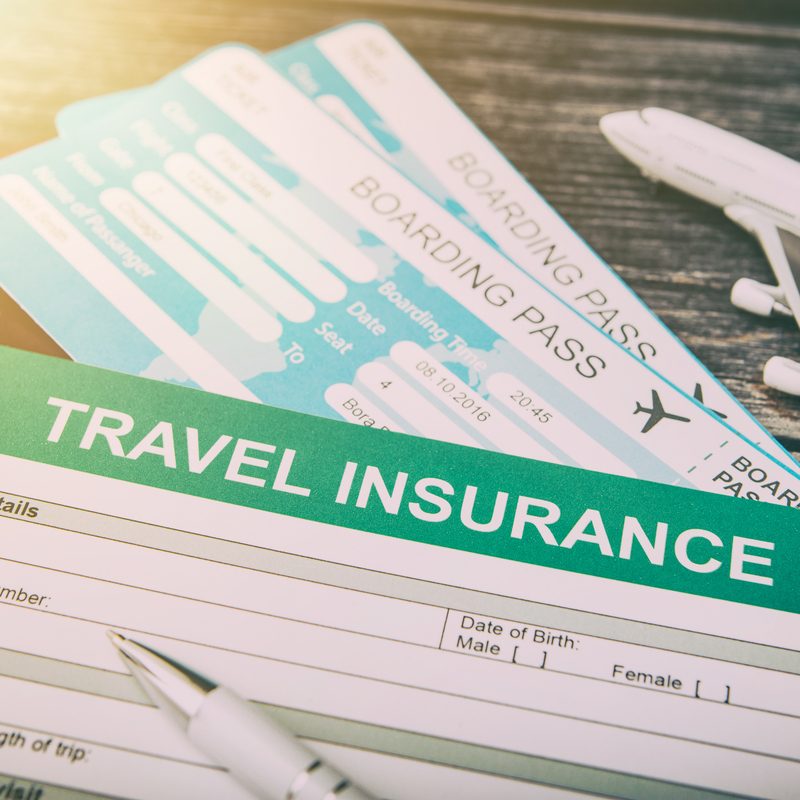 Photo of travel insurance form along with plane tickets.