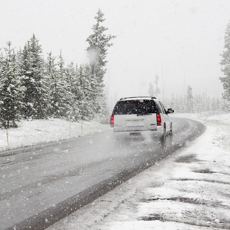 SUV driving down snowy road
