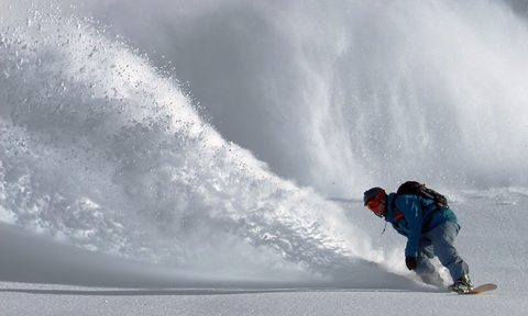 Snowboarder making powder turn