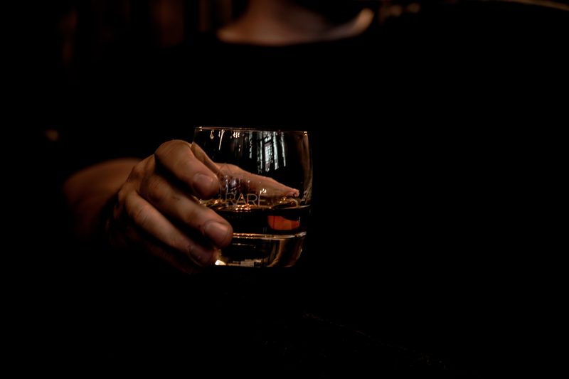 A person holding a glass of bourbon