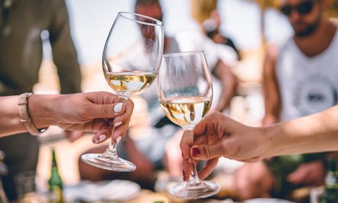Hands toasting with white wine