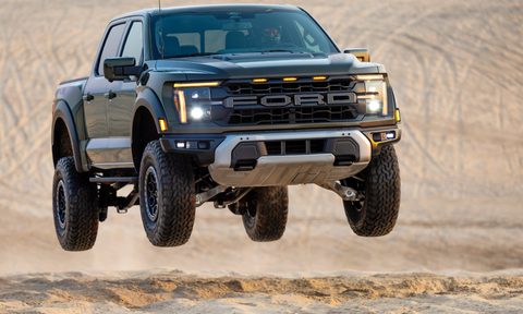 2024 Ford F-150 R airborne as it comes up a desert sand hill.