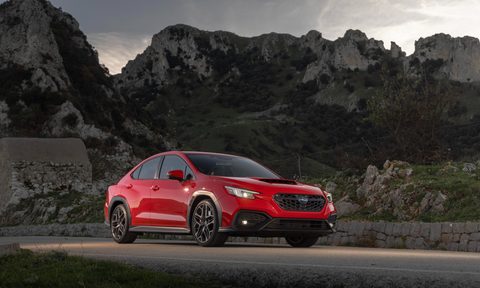 2024 subaru wrx pricing tr with red paint right front three quarter view of the car on a road mountatins in background
