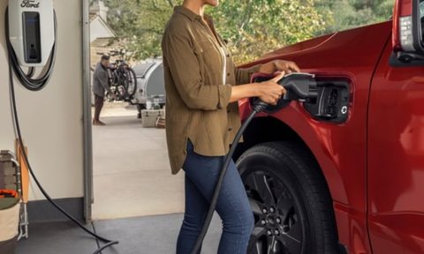 Charging a Ford F-150 Lightning EV with a Level 2 wall charger in a garage.