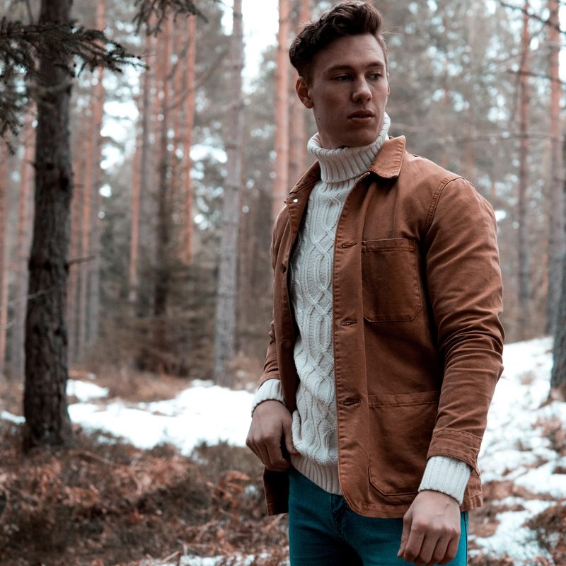 Man in a turtleneck standing in the woods