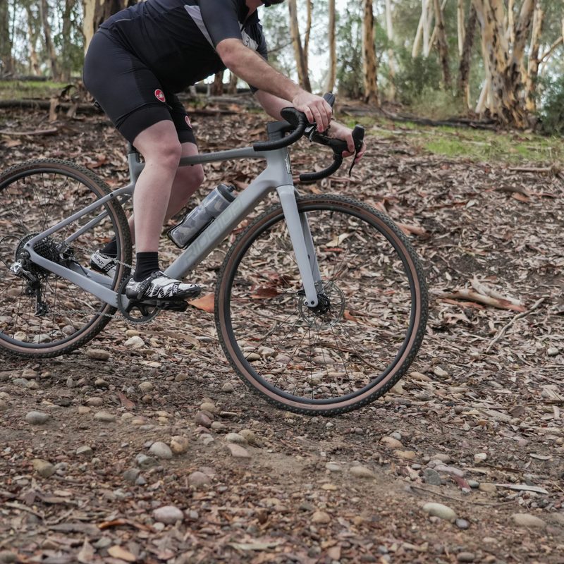 Ride1UP CF Racer1 with rider traversing a rocky hillside.
