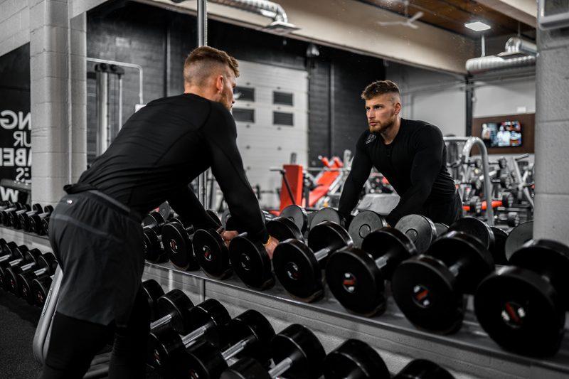man looking in mirror, weight training