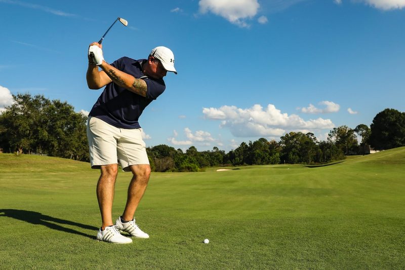 Someone about to take a swing at a golf ball.