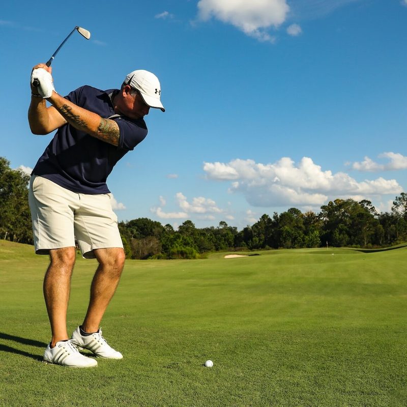 Someone about to take a swing at a golf ball.
