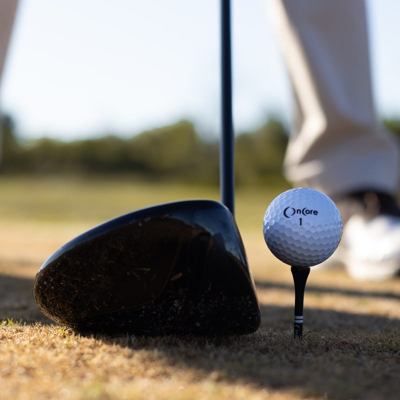 A golfer lining up a club to the ball to hit