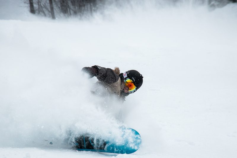 Snowboarder powder turns with goggles