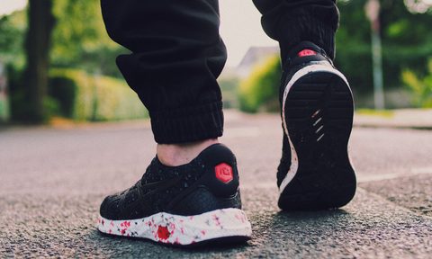 Person in black sneakers walking on the street
