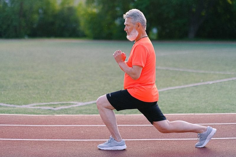 A man doing a lunge on a track