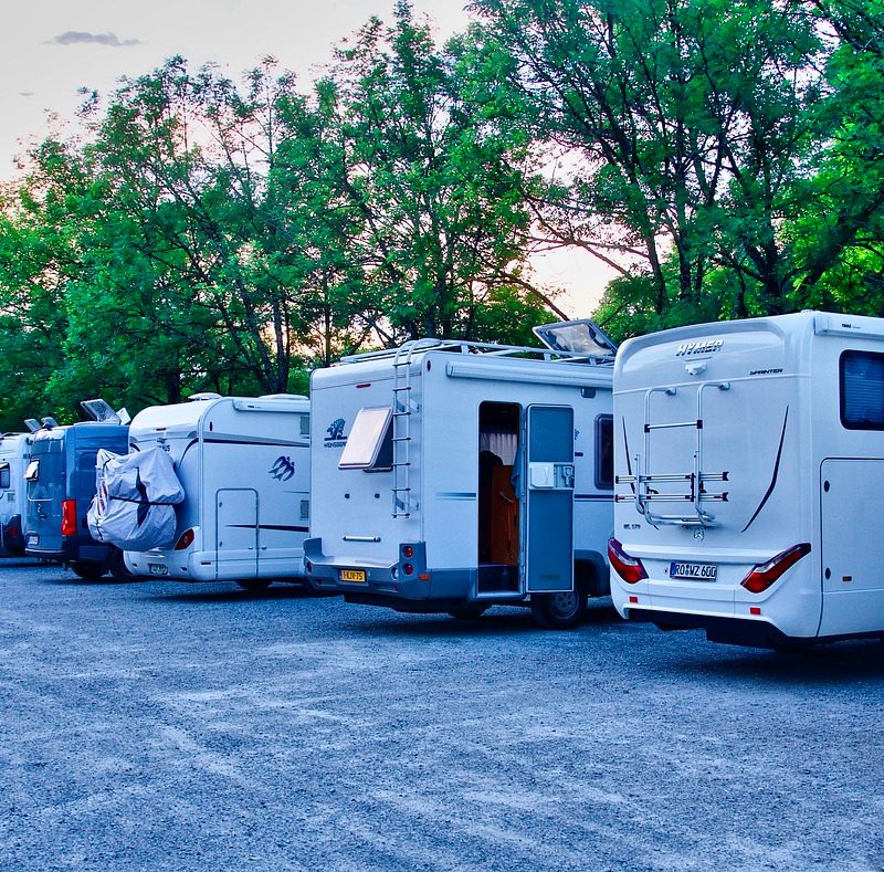 A line of RVs for sale in a wooded lot