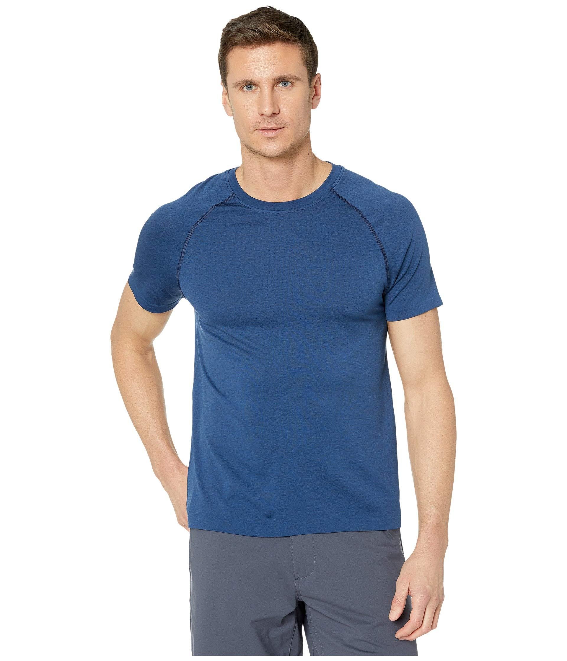 man wearing Rhone Reign tech blue short sleeve workout shirt with white background