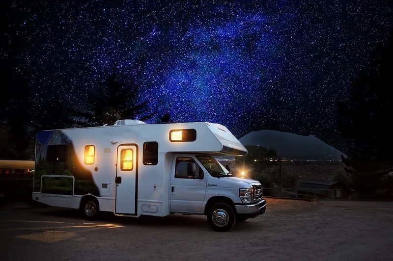 Class C motorhome parked under the night sky