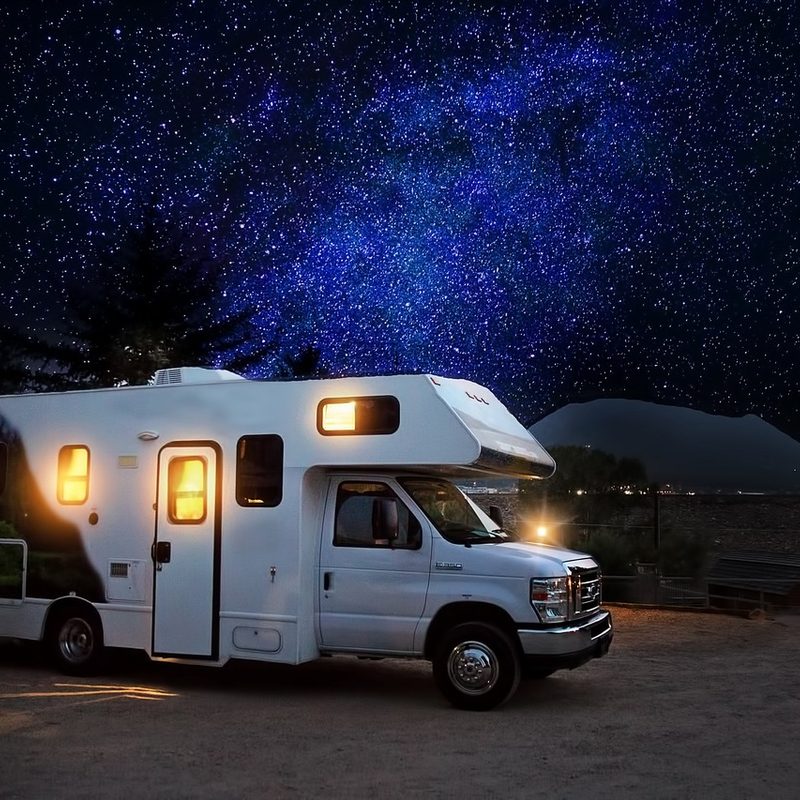Class C motorhome parked under the night sky