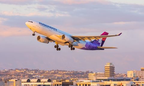 Hawaiian airlines plane flying at sunset