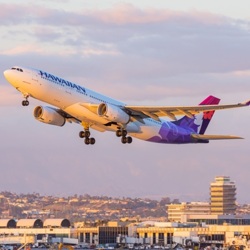 Hawaiian airlines plane flying at sunset