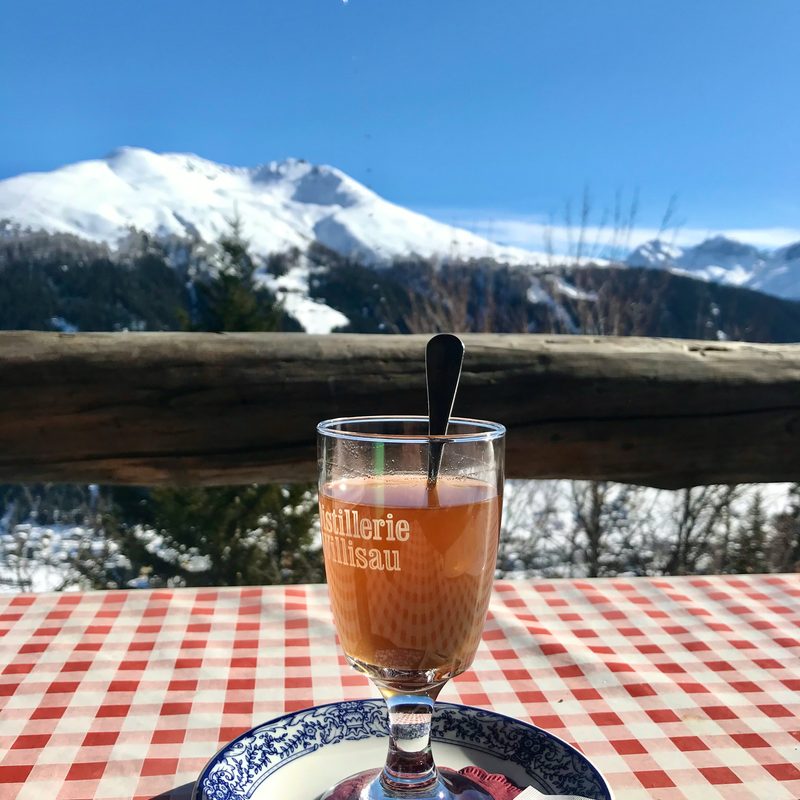 Coffee cup outside on a deck overlooking a snowy mountain