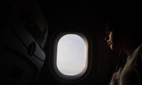 Person looking out plane window
