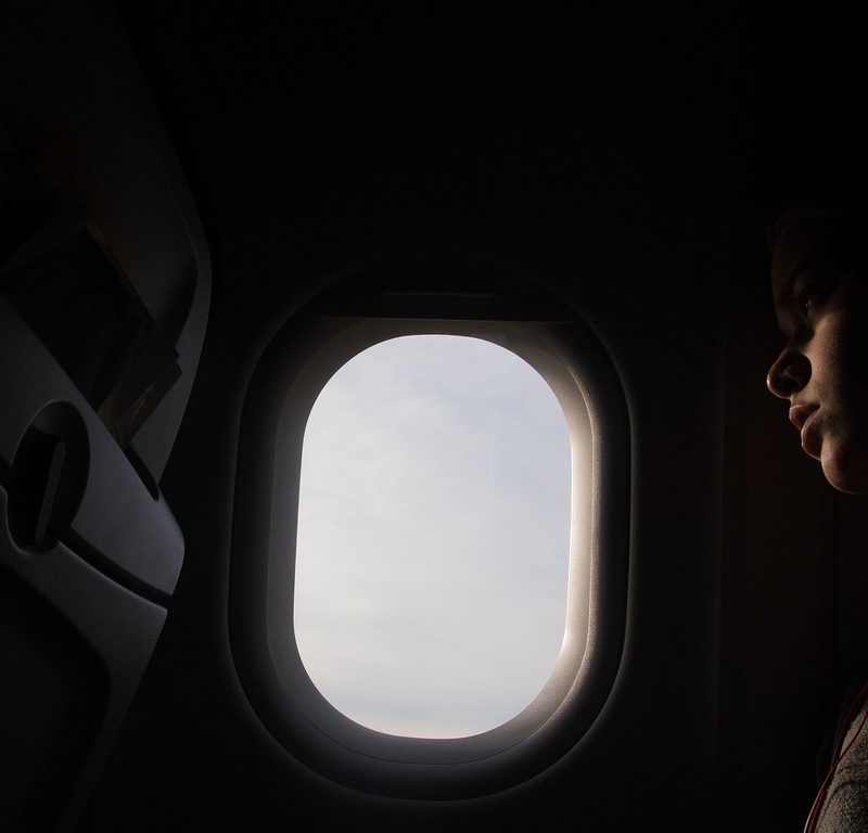 Person looking out plane window