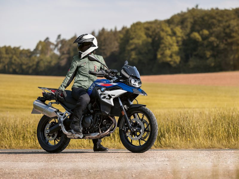 A rider seated on a 2024 BMW F 800 GS and looking back.