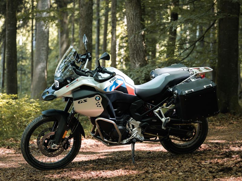 A 2024 BMW F 900 GS Adventure parked on a forest road.