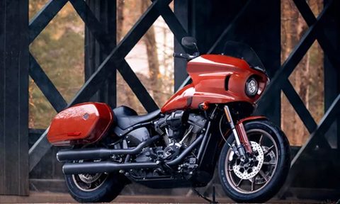 2024 Harley-Davidson Low Rider ST parked on grass under the support structures of an elevated roadway or bridge.