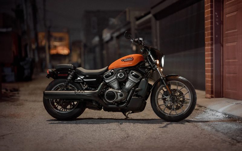 2024 Harley-Davidson Nightster cruiser motorcycle parked in an alley outside a brick building.