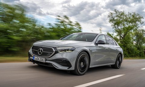 2024 Mercedes-Benz E-Class Sedan left front three-quarter shot driving on road with tress and a cloudy sky in the background.