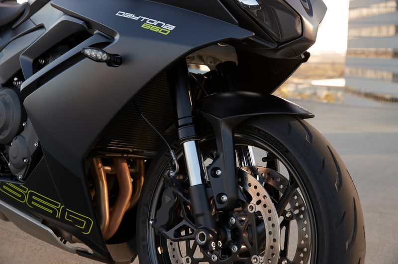 2024 Triumph Daytona 660 close up view of front wheel, brakes, and under fairing with liquid cooling unit.