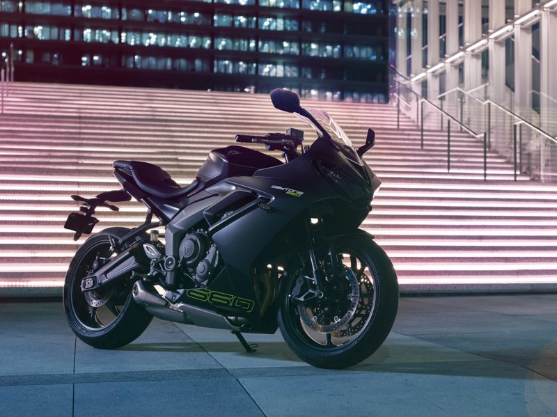 2024 Triumph Daytona 660 parked on polished concrete at the foot of bright stairways with lighted city buildings in the background.