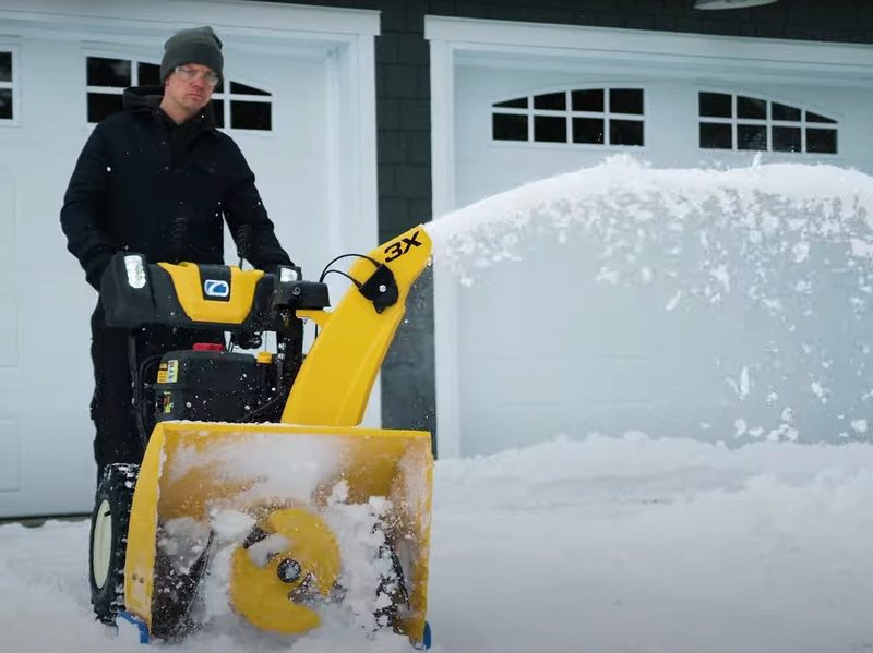 A man uses the Cub Cadet 3X 30-inch IntelliPOWER Snow Blower to clear his wet, heavy snow.