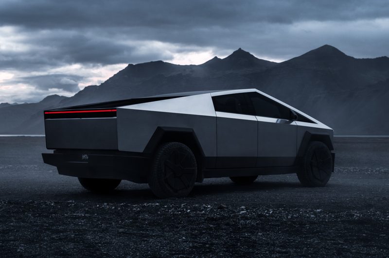 Tesla Cybertruck parked outside with a mountain in the background.