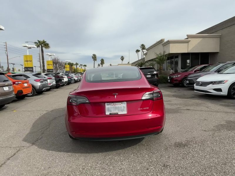 For sale by Hertz 2022 Certified Pre Owned 2022 Tesla Model 3 Long Range sedan red rear view.