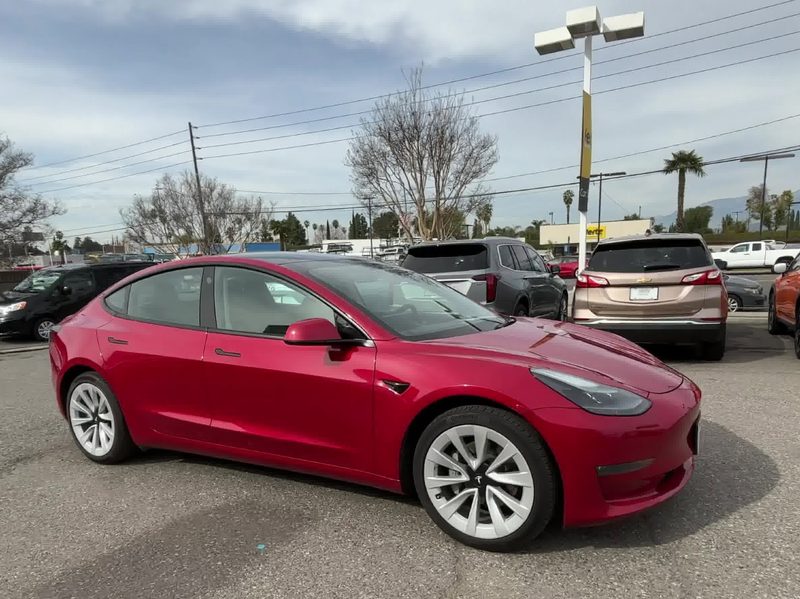 For sale by Hertz 2022 Certified Pre Owned 2022 Tesla Model 3 Long Range sedan red right front side view.