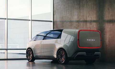 Honda 0 Space-Hub concept EV left rear three-quarter view parked inside a gleaming floor with a wooden wall on the right side and a wall of glass on the left.