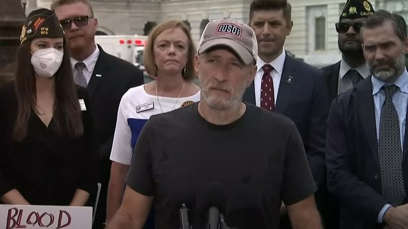 Jon Stewart is flanked by veterans in Washington D.C. in 2022.