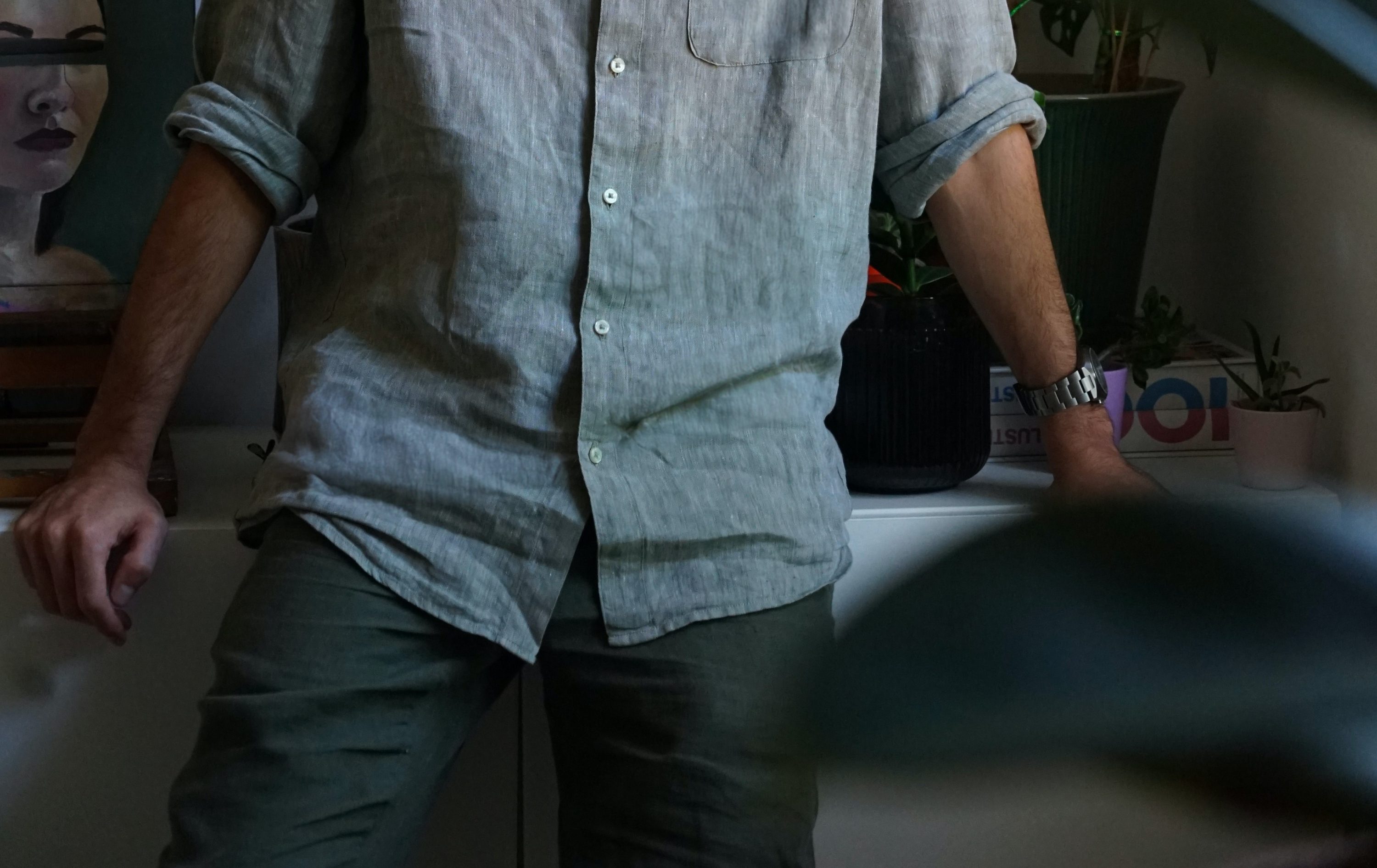 Man in linen leaning on a counter