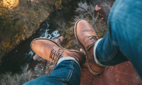 Man on cliff in leather boots