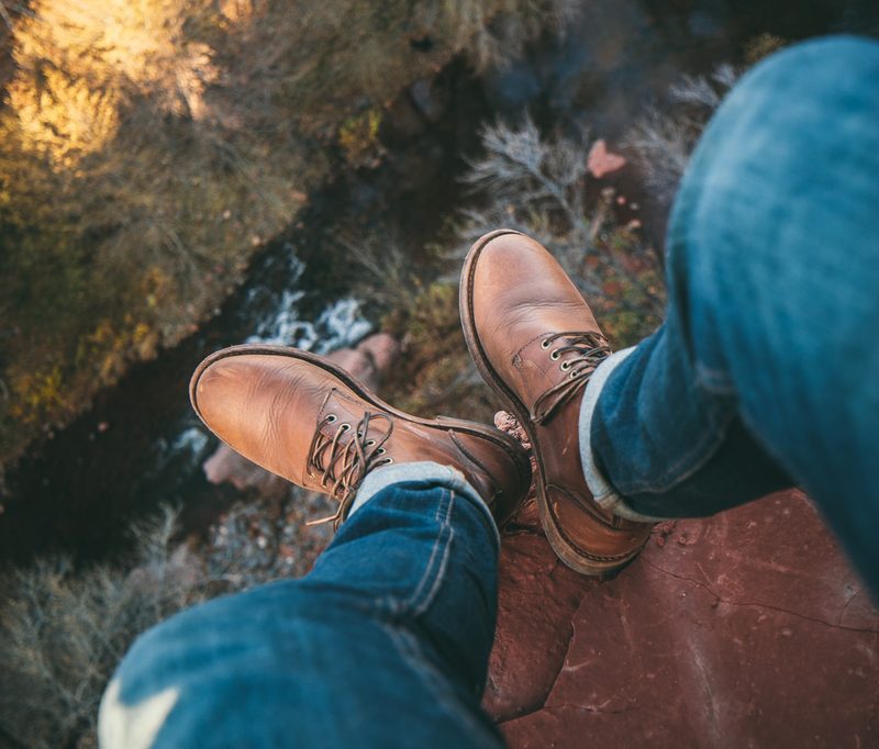 Man on cliff in leather boots