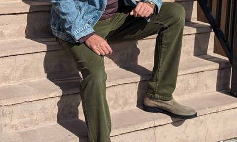 Man sitting on steps in jeans and chukkas
