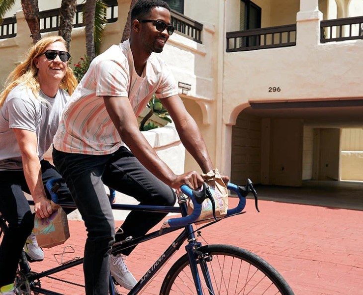Men in Mugsy Jeans riding a bike