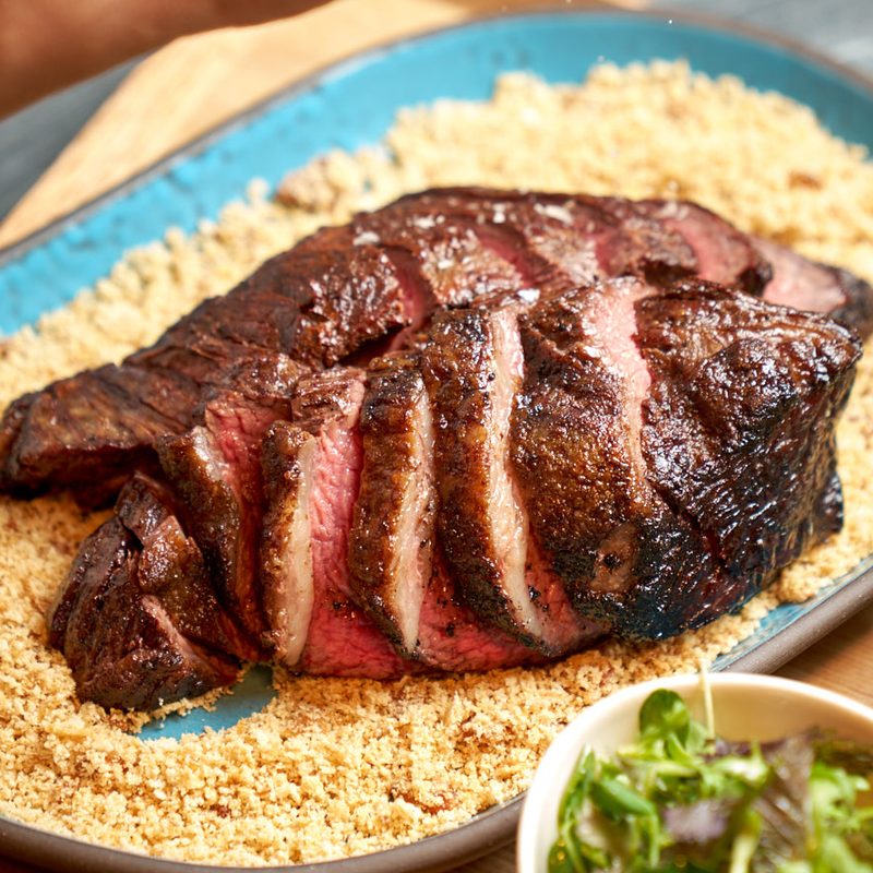 Sliced picanha steak on plate.