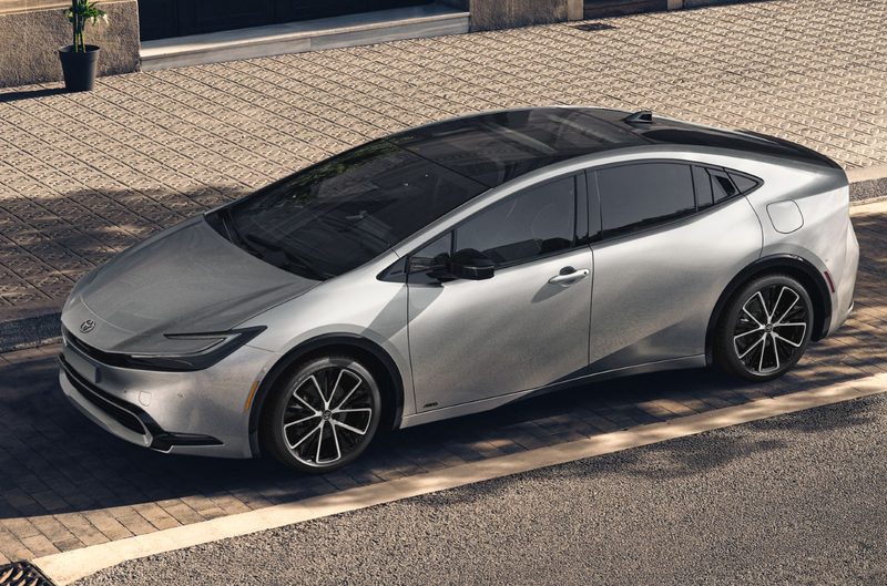 Silver 2024 Toyota Prius sedan parked on a brick lane beside a city street.